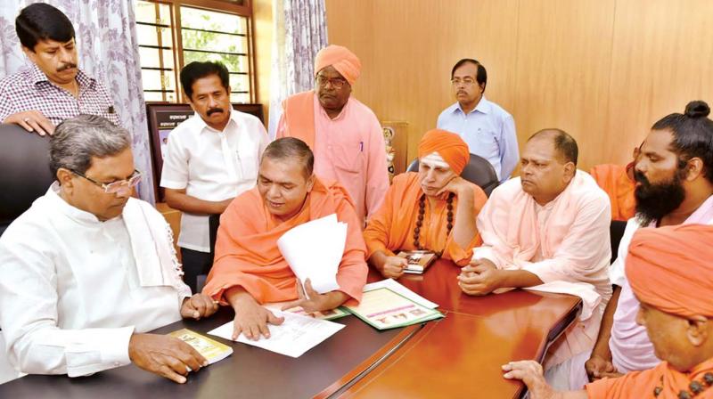 in this file photo, Nidumamidhi Math seer Channamalla Swamiji (centre) seen in discussion with CM Siddaramaiah