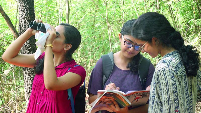 A girl watches birds through a binoculars while her friends take note of the details during their trip to Mamandur. (Photo: DC)