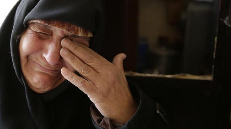 Amina Hamawy cries after she returned to her looted home in the Hanano district of eastern Aleppo, Syria. (Photo: AP)