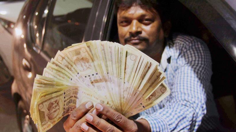A man shows 500 rupees note as the Prime Minister ordered to ban 500 and 1000 rupees notes as part of NDA Govts fight against black money and corruption. (Photo: PTI)