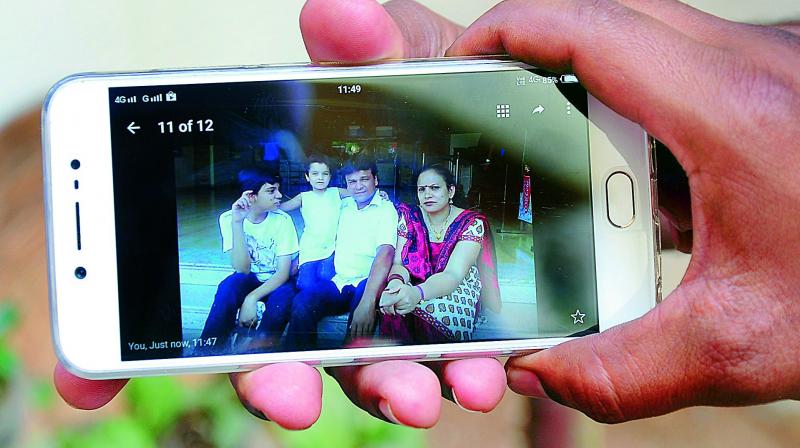 A policeman shows a photo of Deen Benedict and his family captured on a cellphone. (Photo: DC)