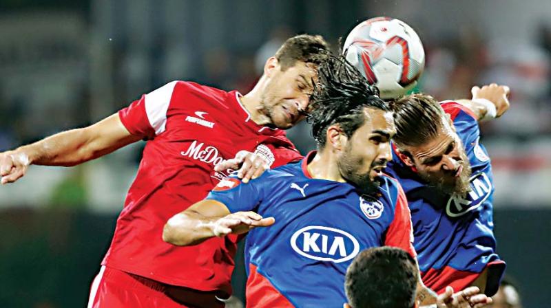 Mato Grgic, left, of Northeast United FC fights for the ball with Dimas Delgado, center, and Eric Paartalu, right, of Bengaluru FC during the Hero Indian Super League (ISL) match. (Photo: AP)