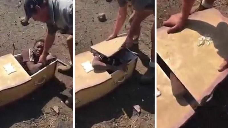 The 20-second clip shows one white man shoving the black man into the coffin and forcing the lid down. (Photo: YouTube Screengrab)