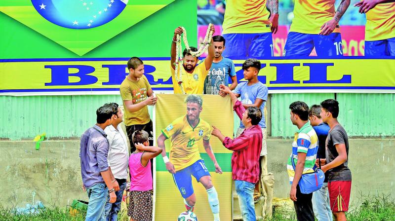 Fans from Kolkata offer a garland to a poster of Neymar. (Photo: AP)