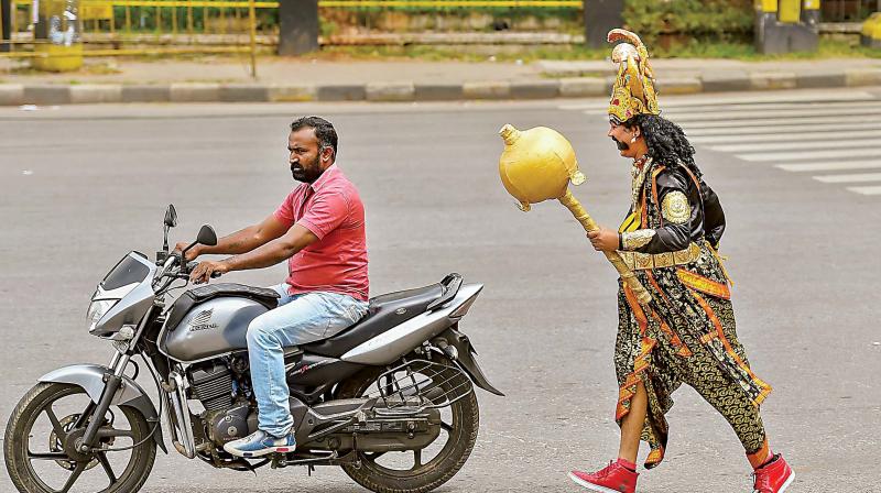 A man dressed as Yamaraja, God of Death, to promote road safety awareness drive organised by city traffic police on JC Road in Bengaluru on Tuesday (Photo: AFP)