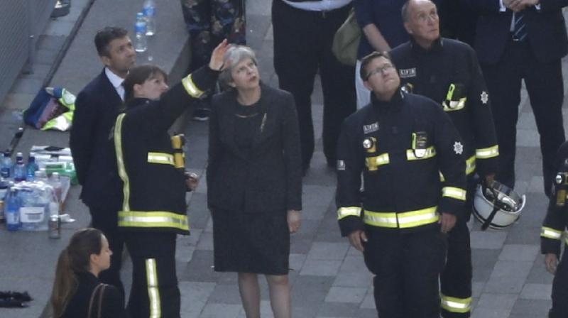 British Prime Minister Theresa May speaks with London Fire Brigade commissioner Dany Cotton as she visits the remains of Grenfell Tower, a residential tower block in west London on June 15, 2017, the day after it was gutted by fire British Prime Minister Theresa May (C) speaks with London Fire Brigade commissioner Dany Cotton as she visits the remains of Grenfell Tower, a residential tower block in west London on June 15, 2017, the day after it was gutted by fire (Photo: AFP)
