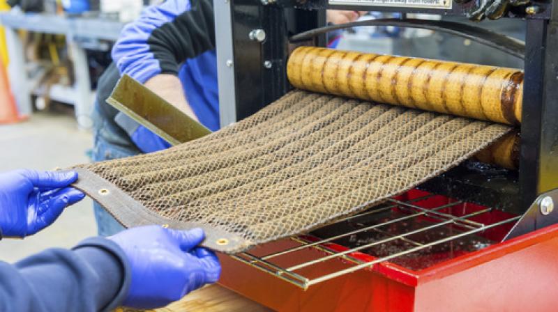 In this December 2016 photo provided by the Argonne National Laboratory, Argonne researchers wring out an \Oleo Sponge\ pad to extract adsorbed crude oil obtained during tests at a seawater tank facility in Leonardo, N.J. Both the oil and the pad can be reused after this process. (Mark Lopez/Argonne National Laboratory via AP) In this December 2016 photo provided by the Argonne National Laboratory, Argonne researchers wring out an \Oleo Sponge\ pad to extract adsorbed crude oil obtained during tests at a seawater tank facility in Leonardo, N.J. Both the oil and the pad can be reused after this process. (Mark Lopez/Argonne National Laboratory via AP)