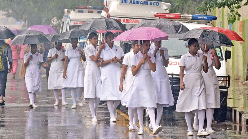 Nursing students walking with umbrellas near Rajiv Gandhi government hospital. (Photo: DC)