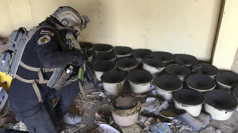 A soldier with Iraqs elite counterterrorism force inspects bombs at a building near to a tunnel made by Islamic State militants in Bartella, Iraq. (Photo: AP)