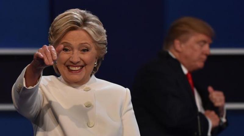 Hillary Clinton waves from the stage following the third and final US presidential debate with Donald Trump (background) at the Thomas & Mack Center on the campus of the University of Las Vegas in Las Vegas, Nevada on October 19, 2016. (Photo: AFP)