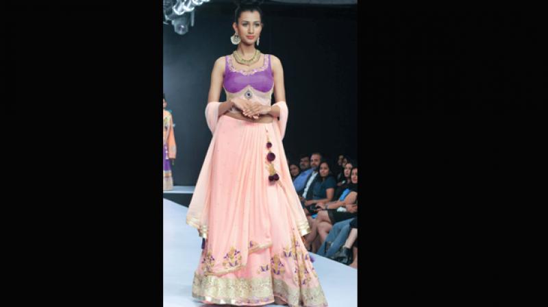 A file pictures of a model wearing a pastel pink lehenga.