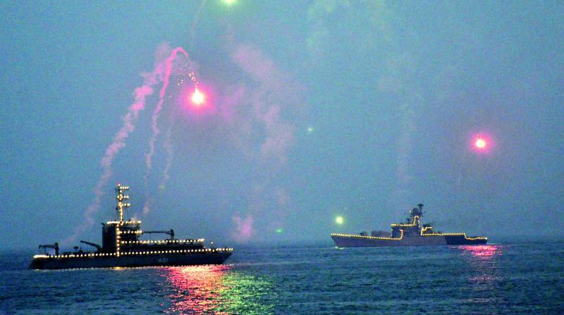 Indian Naval Warships release flares as they were illuminated while anchored off the sea, during the rehearsals for the upcoming Navy Day celebrations at Ramakrishna Beach in Visakhapatnam on Tuesday. (Photo: P. Narasimha Murthy)