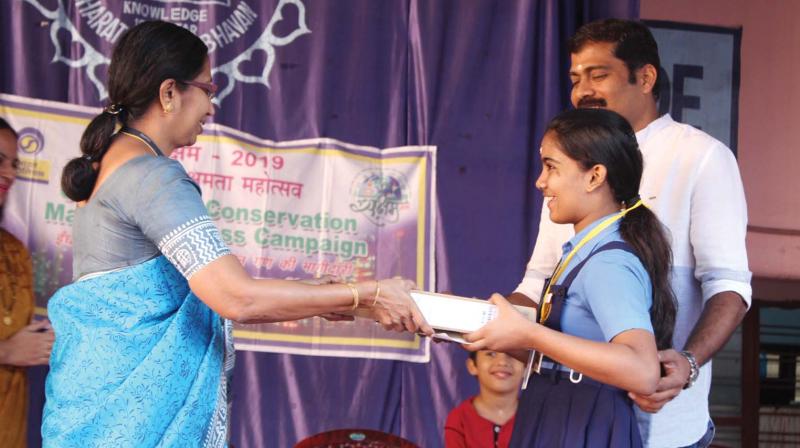 Nandana S. Pillai, student of Std V from Bhavans Vidya Mandir, Girinagar, who secured the first position in the National Science Olympiad 2018-19, being presented with a gold medal, laptop and a certificate by Girija T.S., principal, at the prize distribution ceremony at the school.