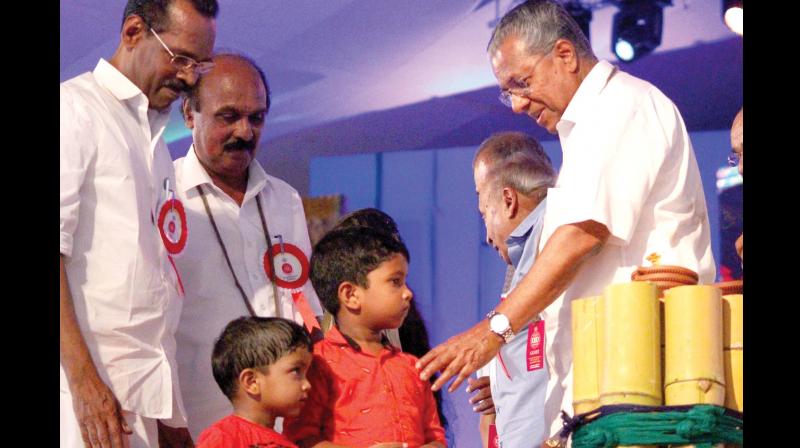 Pinarayi Vijayan with the two children of nurse Liny, who died afflicted with Nipah virus, during the 1000th day celebration function of state government at Kozhikode beach on Wednesday.