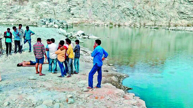 Youths wait with the body of their friend, who was one of the two persons who drowned during a picnic near Ghatkesar on Thursday.