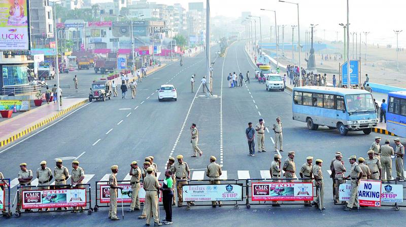 Police personnel barricade a road to prevent people from going to R.K. Beach to take part in a silent protest seeking the special category status for Andhra Pradesh. 	(Photo: DC)
