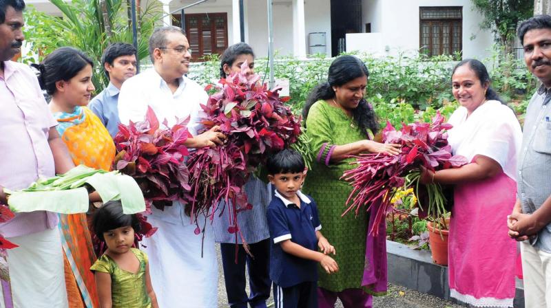Kamala Vijayan, wife of Chief Minister Pinarayi Vijayan handing over a bunch of red spinach to C. L. Mini, agriculture officer at Kudpanakunnu Krishi Bhavan in Thiruvananthapuram. 	DC FILE