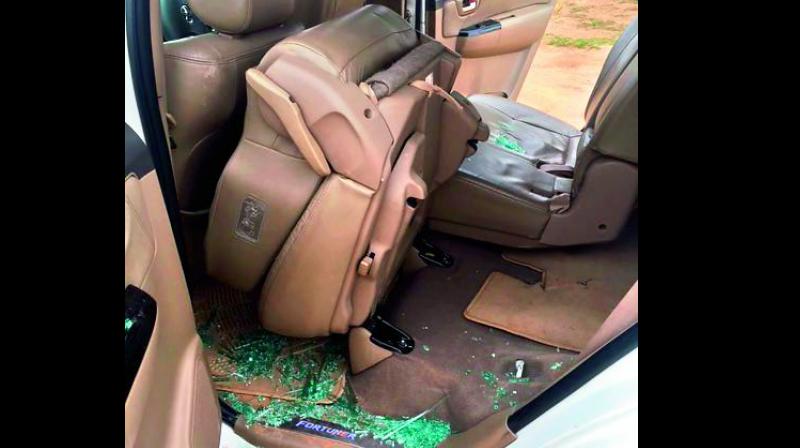 In this picture released by the AICC, broken glass piece are seen inside a car after alleged stone pelting at Congress vice-president Rahul Gandhis convoy during his visit to flood affected Dhanera village of Banaskantha district on Friday. (Photo: PTI)