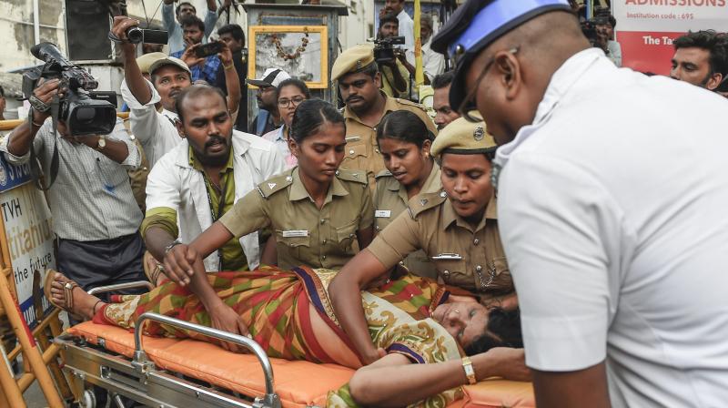 A DMK supporter being taken for treatment after she fainted outside the hospital, where DMK chief M Karunanidhi is being treated, in Chennai on Monday. (Photo: PTI)