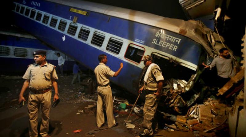 Policemen stand guard near the upturned coaches of the Kalinga-Utkal Express after an accident near Khatauli in Uttar Pradesh. (Photo: PTI)