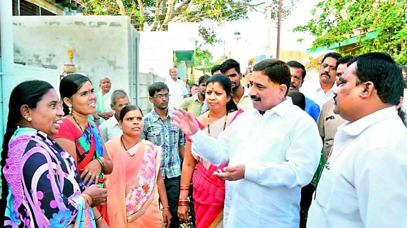 Minister Kalava Srinivas speaks to parents in Gummagatta about joining their daughters back to schools (Photo: DC)