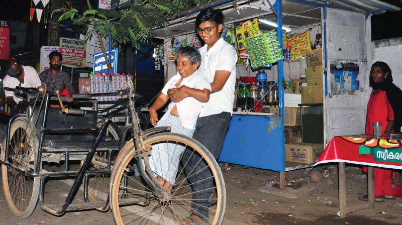 Elder son Shuhaib helps Darvas to the three-wheeler from his shop at Eranhipalam.