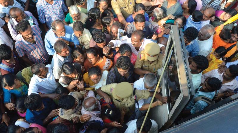Patients rush to enter a police bus to medical college from Thiruvananthapuram Central Railway station due to the strike on  Monday. (Photo: Peethambaran Payyeri )