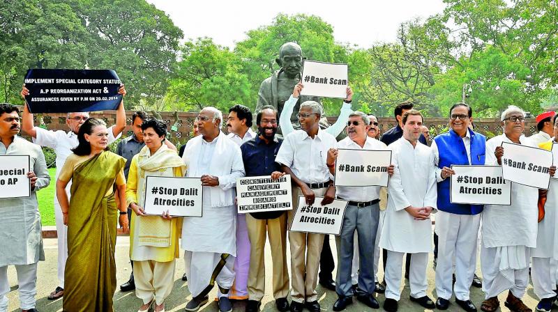 Former Congress president Sonia Gandhi stands along with Opposition party members during a protest outside Parliament during the Budget Session in New Delhi on Thursday. AICC president Rahul Gandhi and other leaders  are also seen. (Photo: PTI )