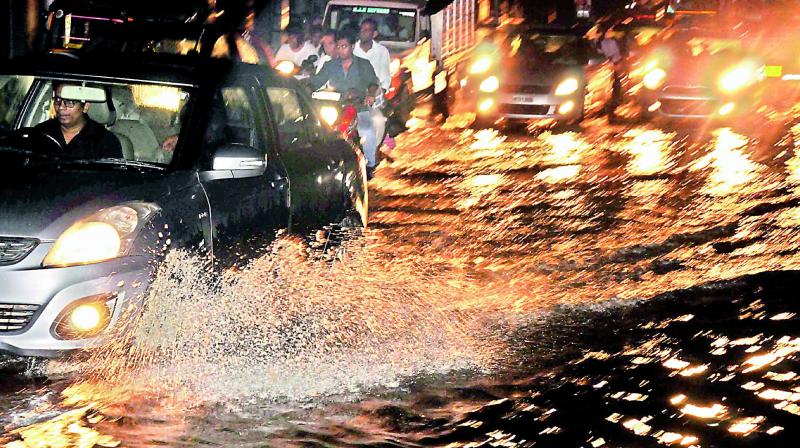 Vehicles wade through the flooded road near Boat Club after a sudden and heavy downpour battered the city on Friday night.	(Photo: P. SURENDRA)
