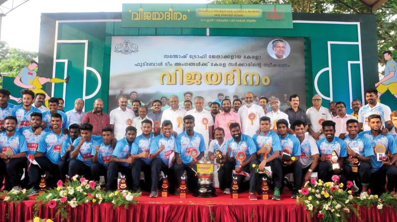 Chief Minister Pinarayi Vijayan and sports minister A.C. Moideen pose for a photo with Kerala football team which won the Santosh Trophy and chief coach Satheevan Balan at the reception organised by government at the Central Stadium in Thiruvananthapuram on Friday. Ministers Kadakampally Surendran, Mathew T. Thomas , Kadannapally Ramachandran, C. Raveendranath, K. Raju, A.K. Saseendran and V.S. Sunil Kumar are also seen. (Photo: A.V. MUZAFAR)