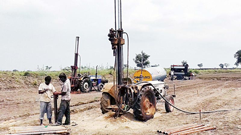 Staff of the agency hired by ONGC drilling  at the farmland in Gadag district. (Photo:  DC)