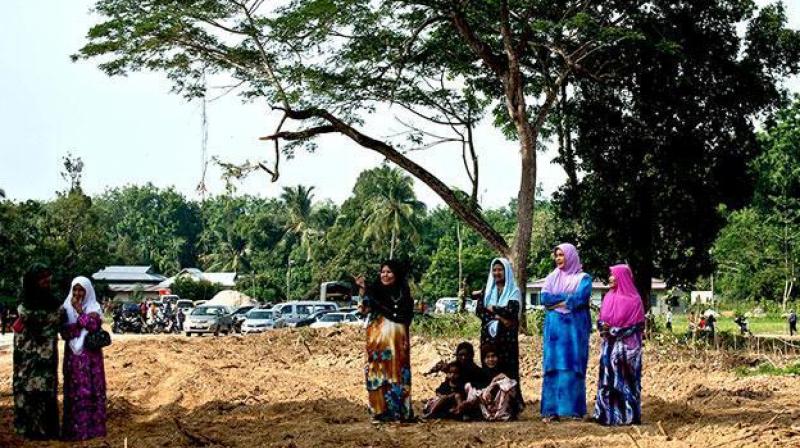 Local Malaysian women watch preparations for the re burial of remains believed to be those of ethnic Rohingya found at human trafficking camps. (Photo: AFP)