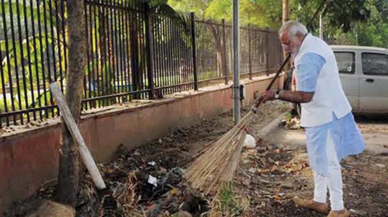 Prime Minister Narendra Modi wields the broom after launch of Swachh Bharat Abhiyan in New Delhi.