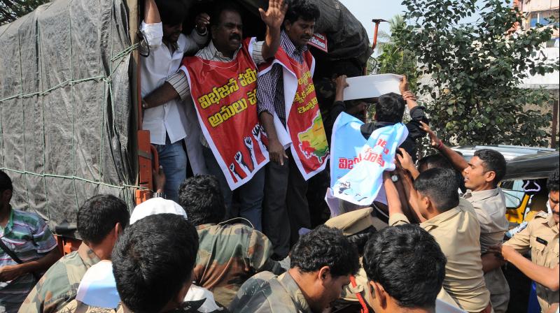 Police personnel detain Left party activists as they stage a protest in Visakhapatnam on Thursday.