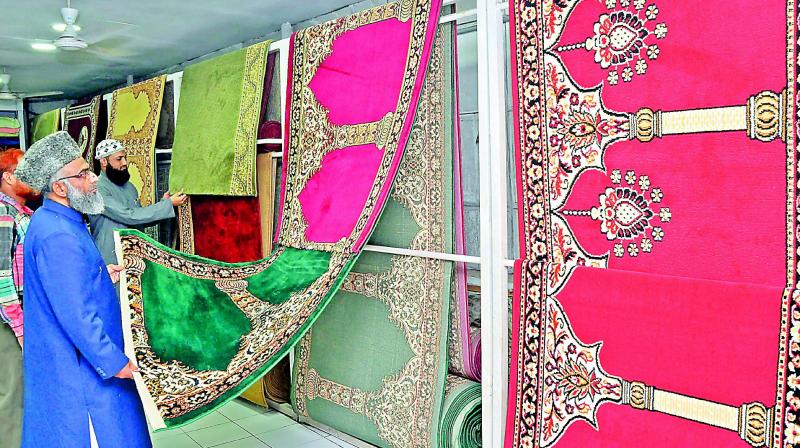 Customers view prayer rugs at one of the carpet shops in the city. With Ramzan a fortnight away, carpet shops in the city have unveiled prayer rugs, known as Musalla. Majority of carpets on display in the city are imported from Iran, Saudi Arabia, Turkey, Indonesia, Belgium and Kashmir. (Photo: DC)