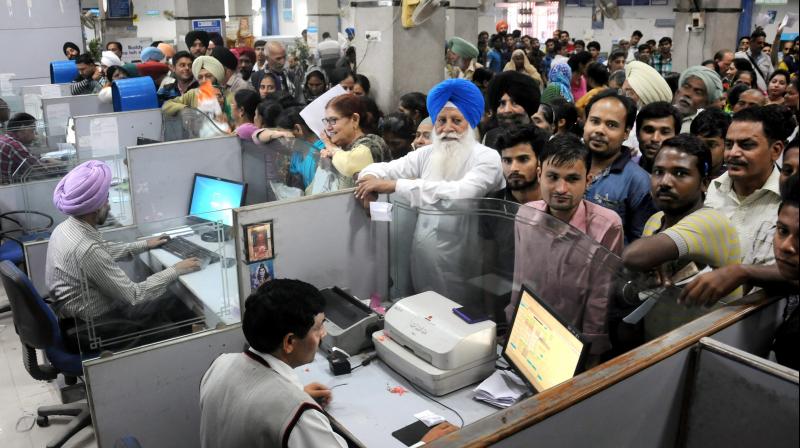People stand in queues in a bank to deposit Rs 1000 and Rs 500 currency notes in Amritsar. (Photo: PTI)