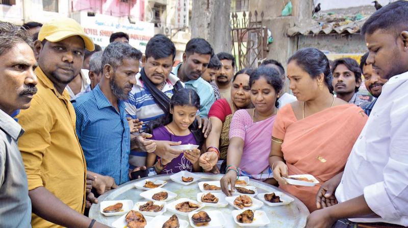 Fish traders at the Chintadripet fish market distribute free fried fish to people (Photo: DC)