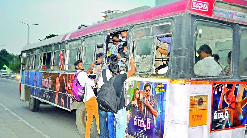 An overcrowded bus is seen in the city with college-going students dangerously hanging out of the rear door. (Photo:P. SURENDRA)