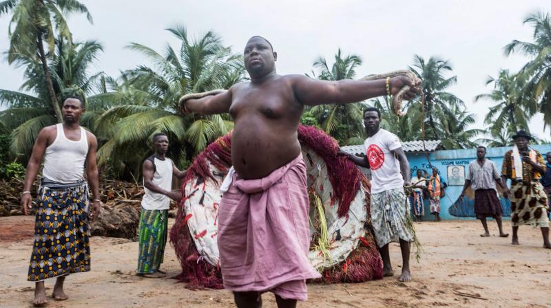 A resident dances with a snake during a ceremony for the guardian of the night Zangbeto a traditional voodoo of the Yoruba religion, in the village of Alongo on May 14, 2018. (Photo: AFP)
