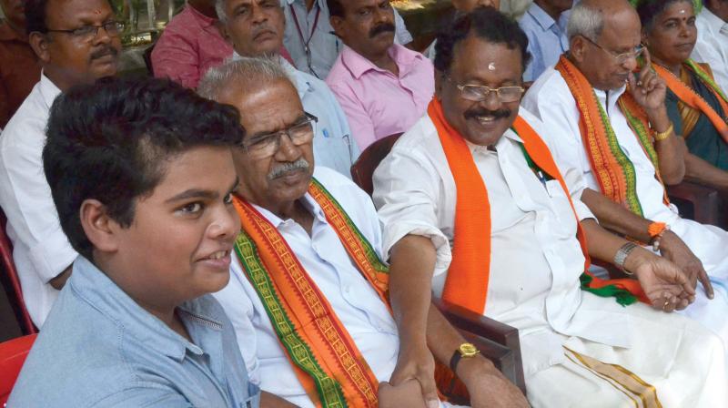BJP state president P.S. Sreedharan Pillai greets Milan Lawrence, grandson of CPM leader M.M. Lawrence  during the fast held in front of the DGP office in Thiruvananthapuram on Tuesday.	 	Peethambaran Payyeri