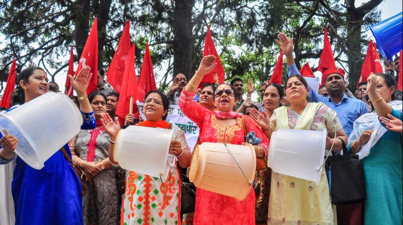 Activists raise slogans with empty buckets during a protest against acute water shortage in Shimla. (Photo: PTI)