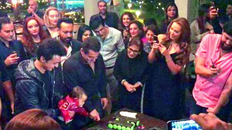 Salman cuts the cake as Iulia clicks pictures.