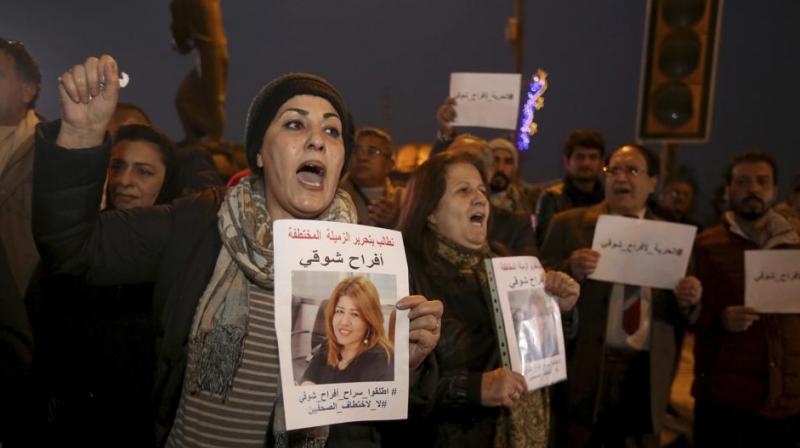 rotesters chant slogans demanding the release of kidnapped journalist Afrah Shawqi al-Qaisi, seen in posters, during a demonstration, in Baghdad. (Photo: AP)