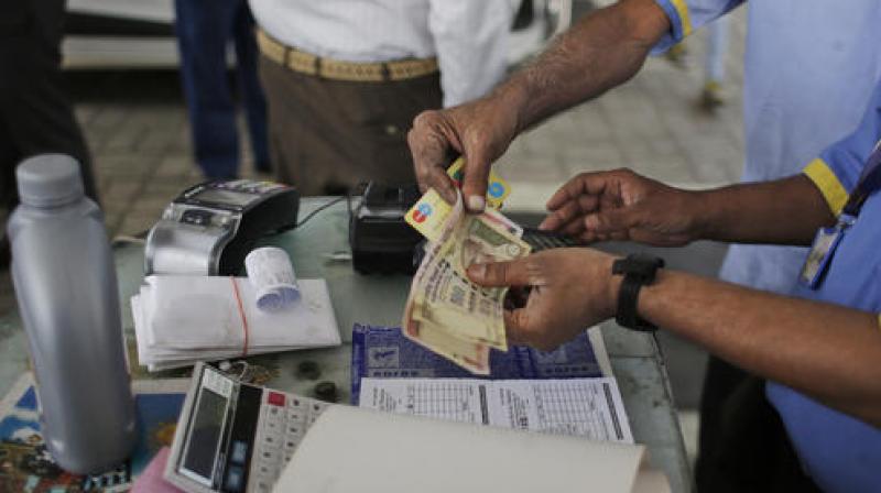 Gas station attendants check 500 and 1000 rupee notes in New Delhi. (Photo: AP)