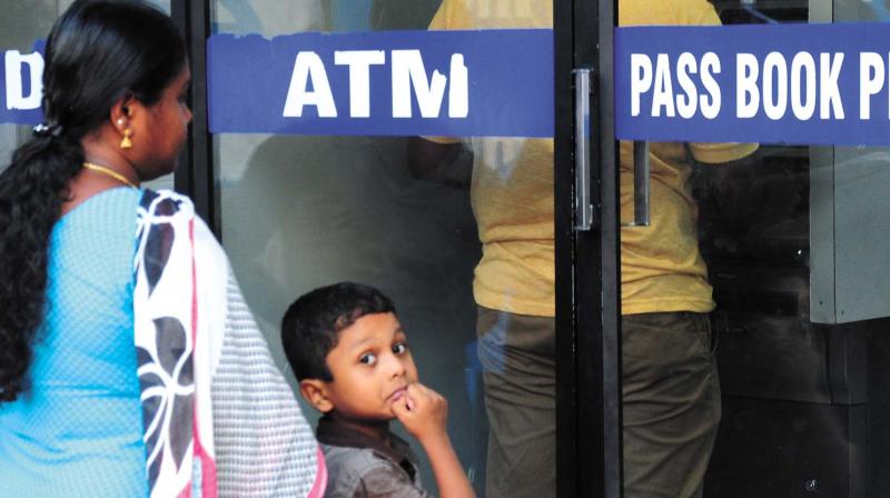 A child was uncertain as he waited with his mother in the queue in front of an ATM counter at Naduvil Junction in MG Road, Thrissur.  However, he beamed when they managed to get some money, finally. 	(Photo: ANUP K. VENU)
