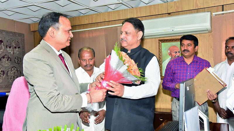 Outgoing Telangana State Chief Secretary S.P. Singh congratulates his successor Shailendra Kumar Joshi after the latter took charge as new CS.