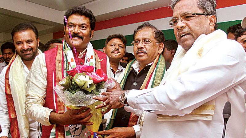 Hosapete MLA Anand Singh is greeted by Chief Minister Siddaramaiah and KPCC chief Dr G. Parameshwar after he joined the Congress, in Bengaluru on Wednesday. (Photo: DC)