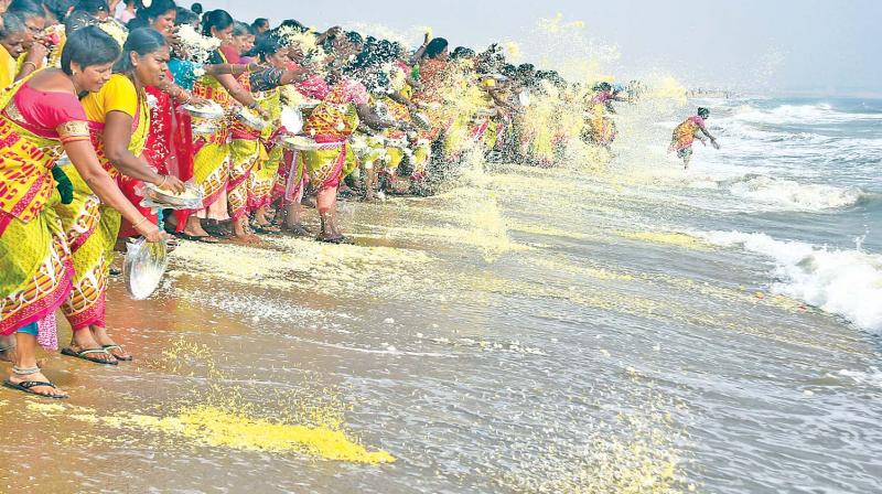 Grief-filled people shower flowers at Marina beach on Monday, marking the 12th anniversary of tsunami. (Photo: DC