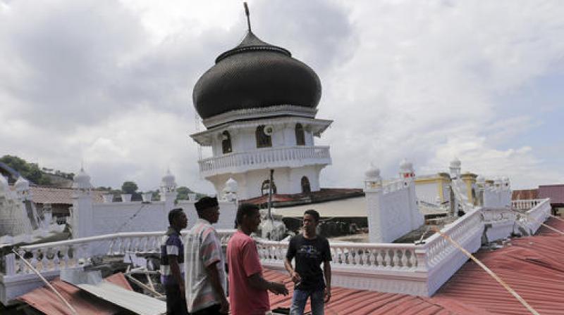 Men inspect a collapsed mosque after an earthquake in Pidie Jaya, Aceh province, Indonesia. (Photo: AP)