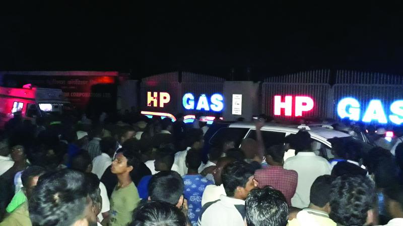 People gather near HPCL unit following the blast on Thursday. 	(Photo:DC)